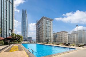 a swimming pool in a city with tall buildings at Dongguan Kande International Hotel in Dongguan