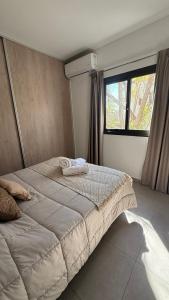 a large bed in a bedroom with a window at Pellegrini Apartments Mendoza !! Estupendos Departamentos con Cochera Privada cercanos a Parque Gral San Martin in Mendoza