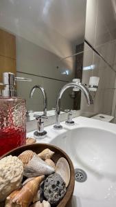 a bathroom with a sink with a bowl of bread at Pellegrini Apartments Mendoza !! Estupendos Departamentos con Cochera Privada cercanos a Parque Gral San Martin in Mendoza +76 photos