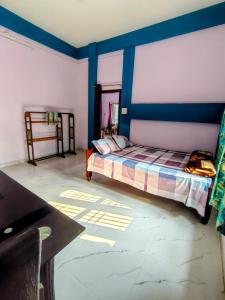 a bedroom with a bed with blue walls and a table at Makum Homestay in Mākum