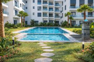 a swimming pool in front of a building at Affordable Luxury Apartment in Nouaseur +2 photos