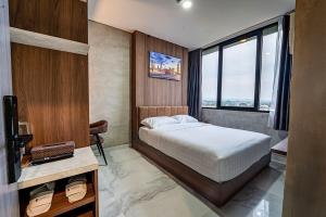 a bedroom with a bed and a desk and a television at Trifena Residence in Kalibanteng-lor +14 photos