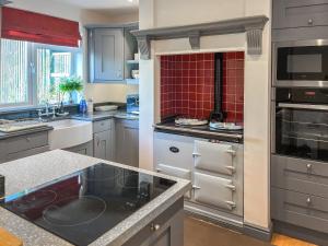 a kitchen with gray cabinets and red tile at Island House - Uk51001 in Little Baddow