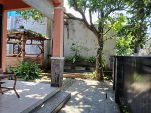 a patio with a table and a tree and a building at Mangga in Sengkaling