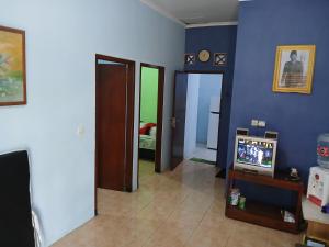 a living room with a tv and blue walls at Mangga in Sengkaling
