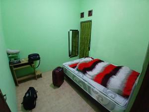 a bedroom with a bed in a room with a mirror at Mangga in Sengkaling