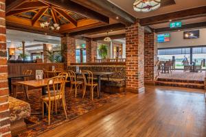 a restaurant with brick walls and tables and chairs at Harrington River Lodge in Harrington