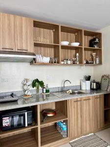 a kitchen with wooden cabinets and a sink at Mactan Plains Residences in Mactan