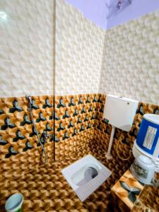 a bathroom with a toilet in a tiled room at Makum Homestay in Mākum