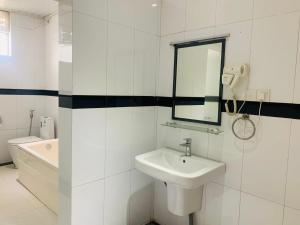 a white bathroom with a sink and a mirror at The Residence Dambulla in Dambulla