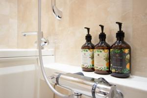 three bottles of wine sitting on a bathroom sink at Fam Hotel Imaizumi in Fukuoka +51 photos