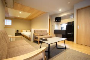 a hotel room with a bed and a couch and a table at Fam Hotel Imaizumi in Fukuoka