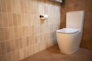 a bathroom with a toilet and a roll of toilet paper at Pacific Sun Bargara in Bargara