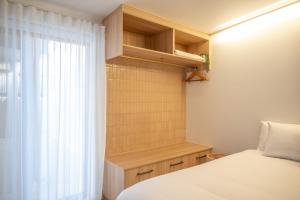a small bedroom with a bed and a window at Pacific Sun Bargara in Bargara