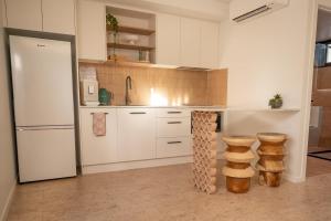 a kitchen with white cabinets and a white refrigerator at Pacific Sun Bargara in Bargara +84 photos