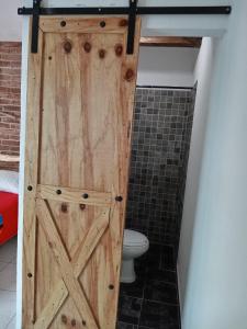 a wooden door in a bathroom with a toilet at Hospedaje Samao in Santa María del Oro