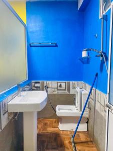 a blue bathroom with a sink and a toilet at Pick Me Village in Dambulla +40 photos