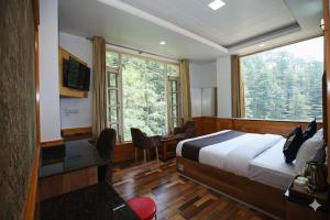 a bedroom with a bed and a desk and a window at Decent Stays Rooms and Apartments in Shimla