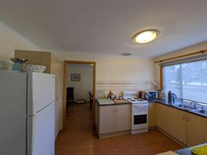 a kitchen with a white refrigerator and a window at Swallows Nest in Cape Bridgewater +6 photos