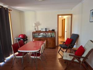 a living room with a red table and chairs at Swallows Nest in Cape Bridgewater