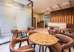 a restaurant with tables and chairs and a counter at Trifena Residence in Kalibanteng-lor