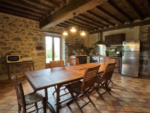 a large kitchen with a wooden table and chairs at Maison poumarou in Sainte-Colome