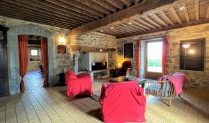 a living room with red chairs and a table at Maison poumarou in Sainte-Colome