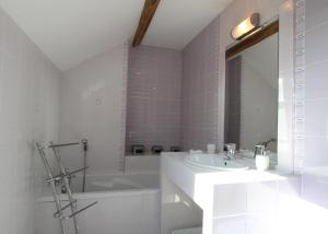 a white bathroom with a tub and a sink and a bath tubermott at Peyre in Aramits +24 photos
