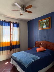 a bedroom with a bed and a ceiling fan at Casa Refugio Budget House 8 Rooms & 9 Bathrooms in Oaxaca City