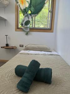 a bed with two pillows on it with a window at Cabaña Rei miro in Hanga Roa
