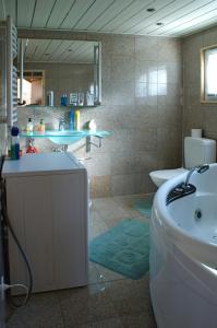 ein Badezimmer mit einer Badewanne, einem Waschbecken und einem WC in der Unterkunft Chalet Abendruh in Grengiols