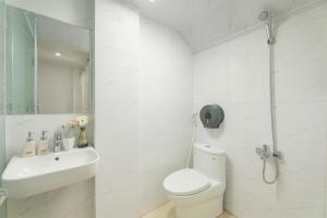 a white bathroom with a toilet and a sink at Miah Ha Noi Hotel - the best choice in Hà Nội Old Quarter in Hanoi