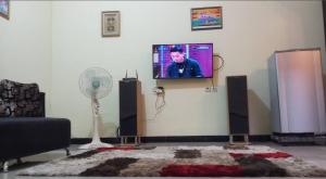 a living room with a flat screen tv on a wall at Homely Guest House Tegal in Tegal