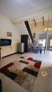 a living room with a rug on the floor at Homely Guest House Tegal in Tegal