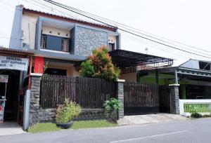 a house with a fence in front of it at Homely Guest House Tegal in Tegal