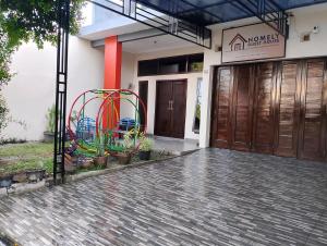 a front door of a building with a colorful orb at Homely Guest House Tegal in Tegal +5 photos