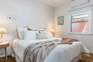 a white bedroom with a bed with a blanket on it at Selah - 36 Woodburn Street in Evans Head