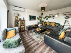a living room with two couches and a table at Sea-Scape in Penrhyn Bay