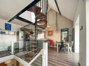 a spiral staircase in a room with a dining room at Sea-Scape in Penrhyn Bay