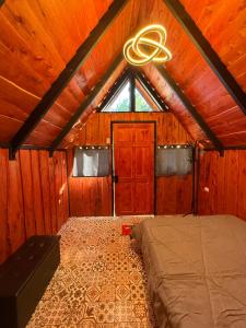 a bedroom with a bed in a room with wooden walls at Cabaña Joy-C Colibri 1 in El Copey