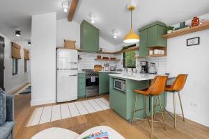 a kitchen with green cabinets and orange chairs at Newly Remodeled Bayview Cabin 6! in Traverse City