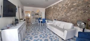 a living room with a white couch and a stone wall at villa lucia in Conca dei Marini