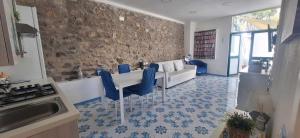 a living room with a white table and blue chairs at villa lucia in Conca dei Marini