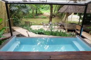 a swimming pool in the middle of a yard with a table at pannaburee resort in Ban Khanong Phra Klang (1)