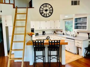 a kitchen with a large clock on the wall at Riverfront with EV charger - Sequoia River Cottage in Three Rivers