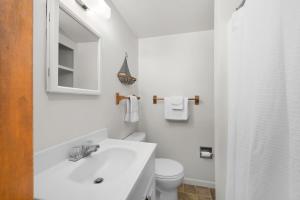 a white bathroom with a sink and a toilet at Topico Cabin 5 . Topico Cabin 5 in Traverse City