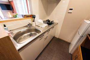 a small kitchen with a sink and a stove at MEIBI Hakone Yumoto in Hakone +58 photos