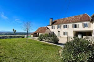 a large white house with a green yard at Gite du coos in Audaux