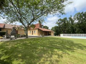 a house with a large yard with a tree at Chez file in Séméacq-Blachon
