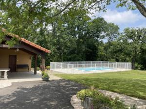 a fence around a swimming pool in a yard at Chez file in Séméacq-Blachon